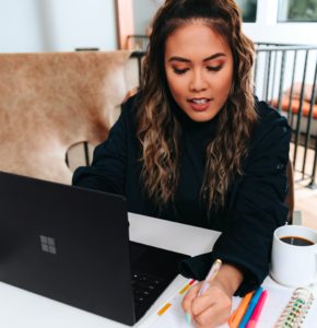 young woman working with laptop and notebook